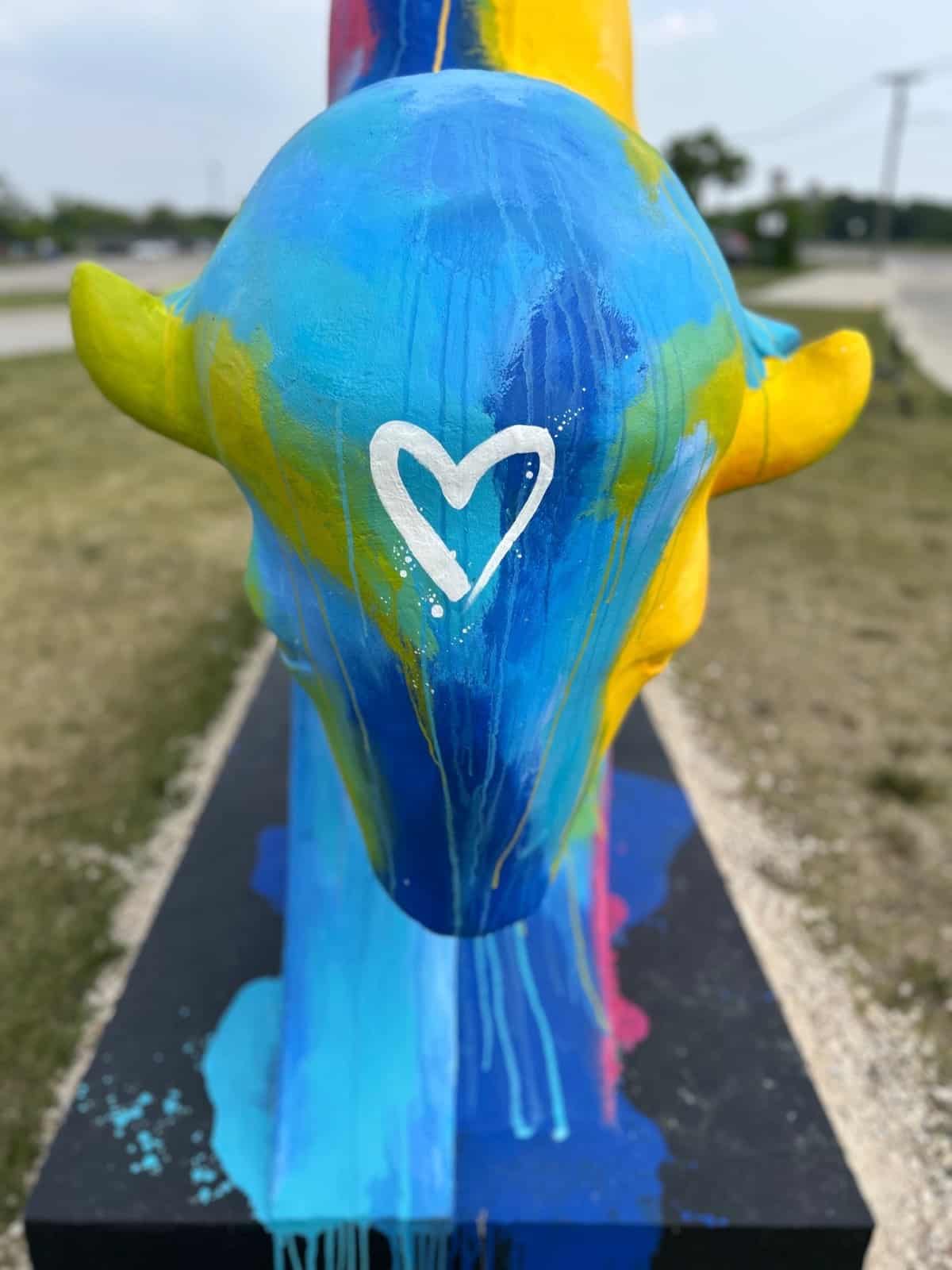 Concrete bison painted with vibrant colours (yellow, blue, pink, green)